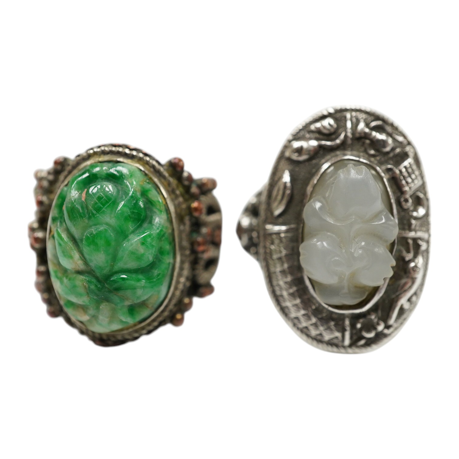 Two Chinese or Burmese jadeite or jade mounted white metal rings. Condition - fair